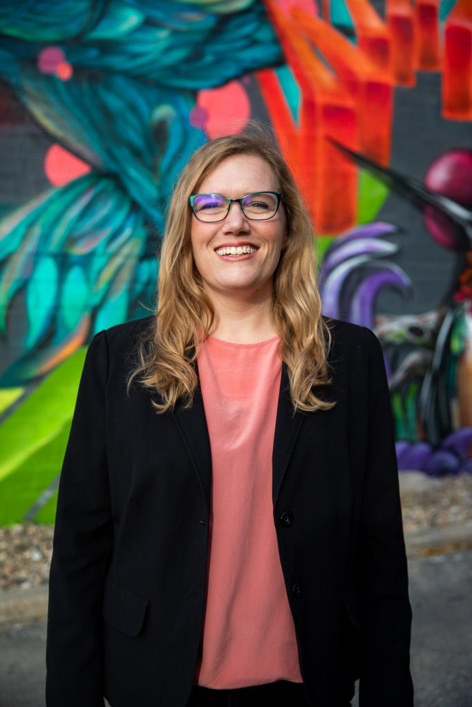 Dr. Dara Wald standing in front of a colorful wall