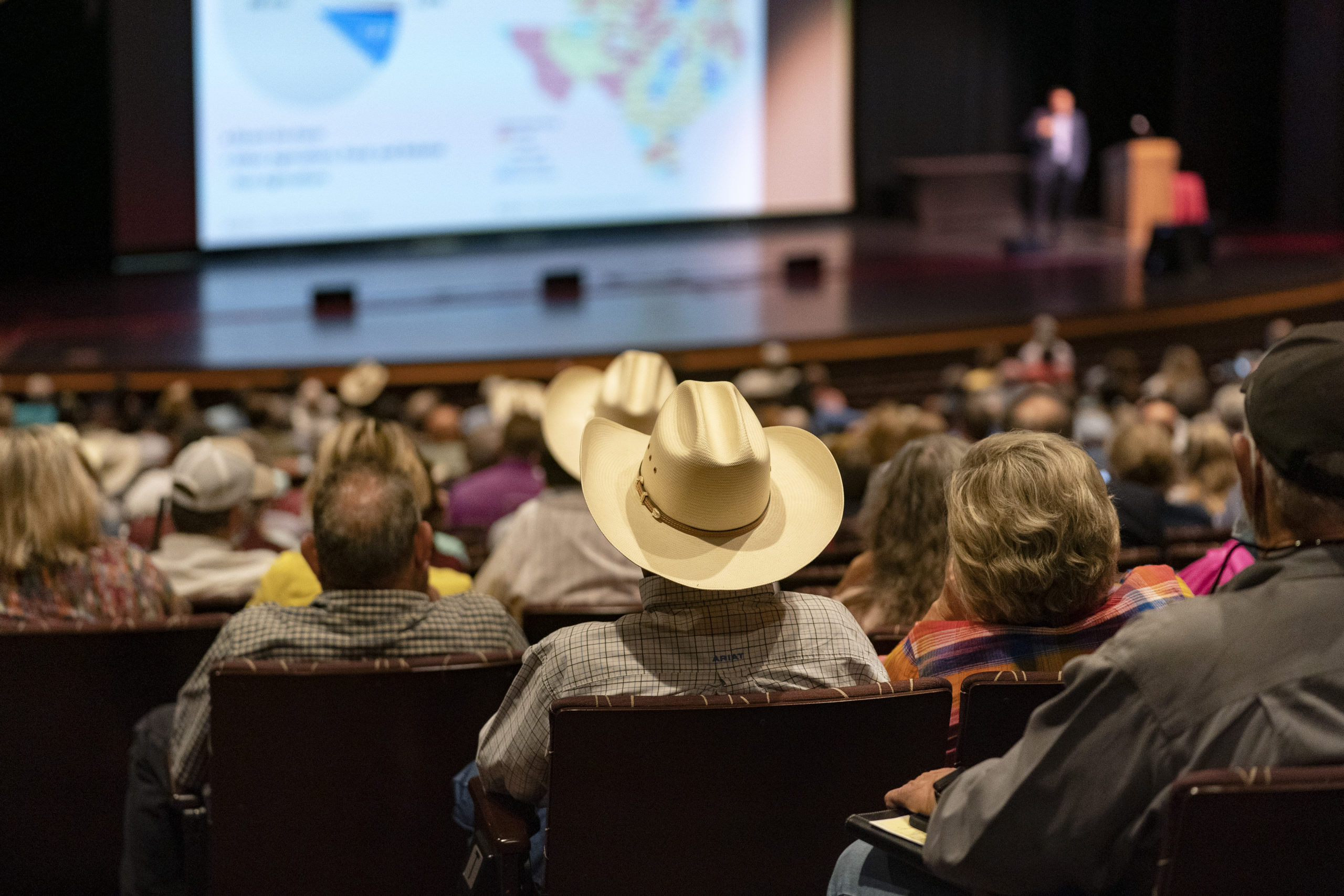 Large group of people sitting listening to a presenter