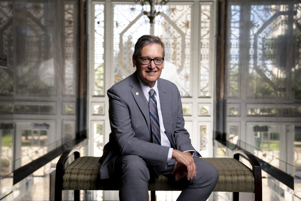 Dr. Matt Baker sitting in front of an intricate window design