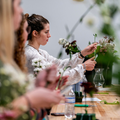 Student intently working on a floral bouquet