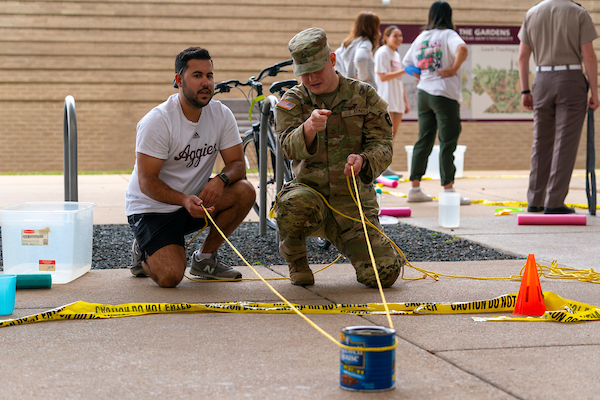 Students holding ropes while working on Agricultural Leadership and Development class project outside