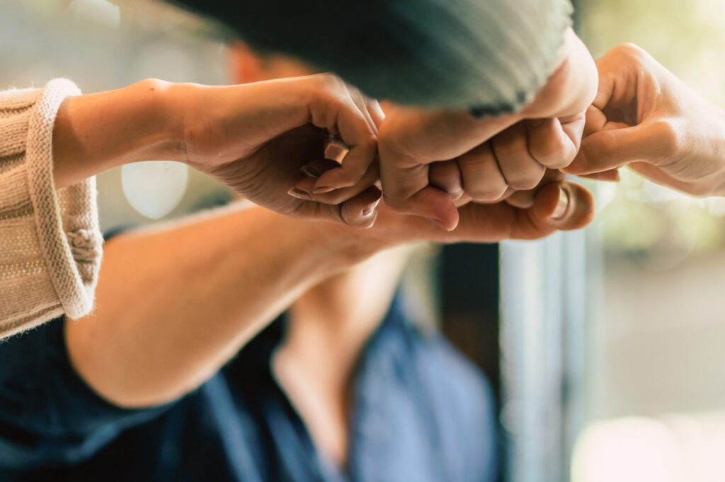 Four people doing a four way fist bump