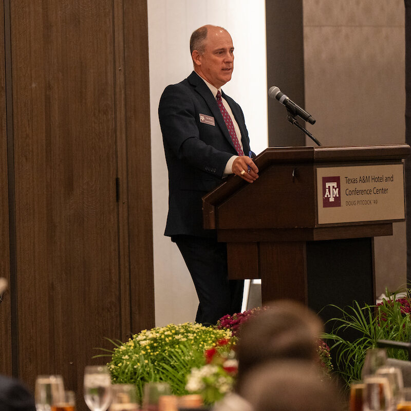 Speaker standing in front of a podium while giving a speech. 