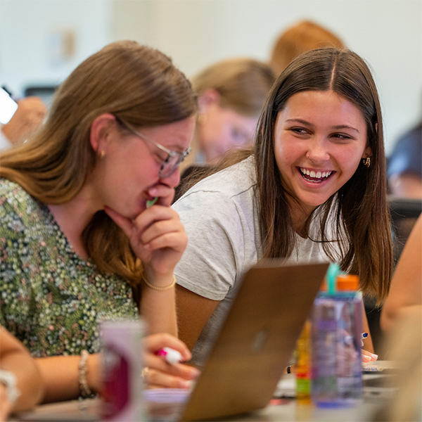 two female students laughing in class